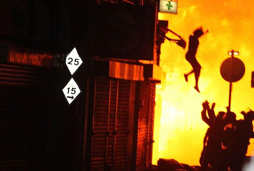 Sieviete lec no degošas ēkas... Autors: cuchins Aizvadītā 2011 spēcīgākās bildes!